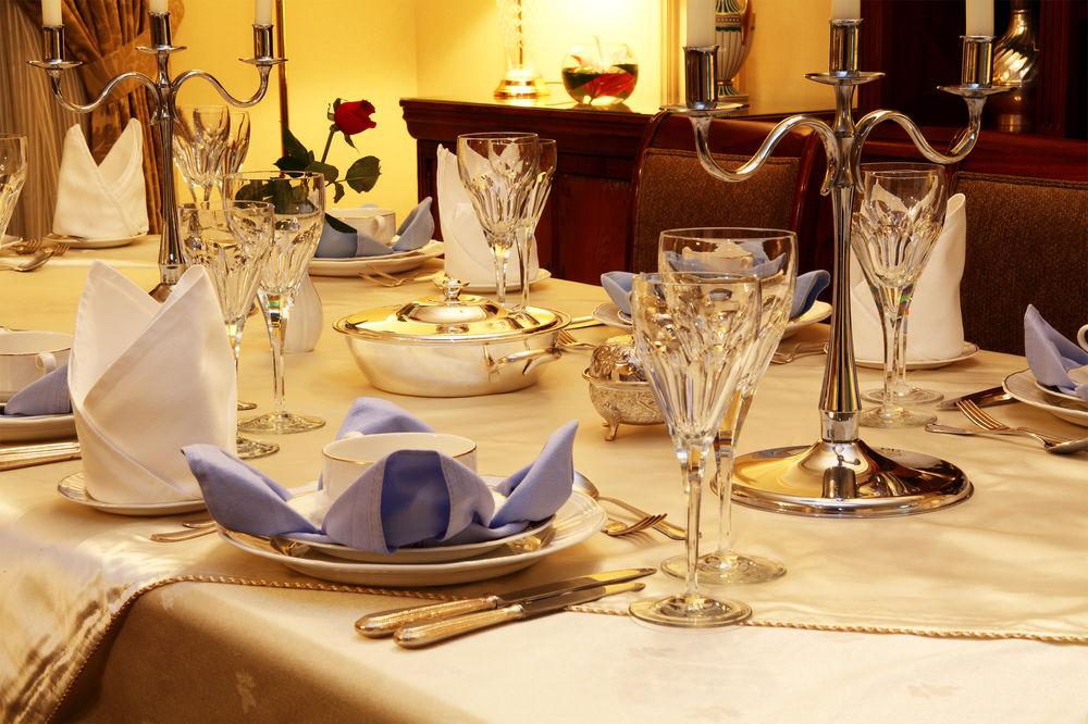 Intercontinental Dar Al Iman Madinah By Ihg Hotell Medina Exteriör bild The image shows a beautifully arranged dining table set for a formal occasion. The table is covered with a light-colored tablecloth, and the place settings include elegant dinnerware, including plates and crystal glassware. 

Each place setting has f