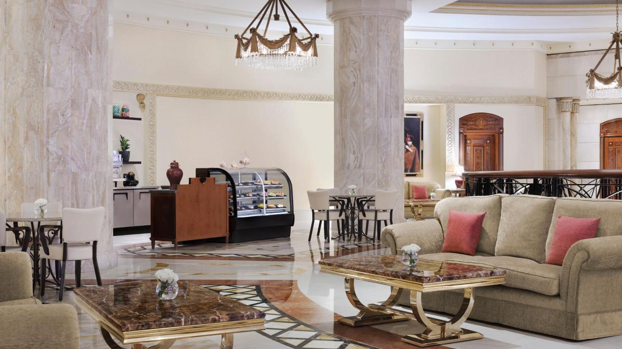Intercontinental Dar Al Iman Madinah By Ihg Hotell Medina Exteriör bild The photo shows a luxurious hotel lobby or lounge area. It features elegant marble floors and tall columns. There are comfortable seating arrangements with a sofa and stylish tables that have marble tops. A display case for pastries or refreshments i