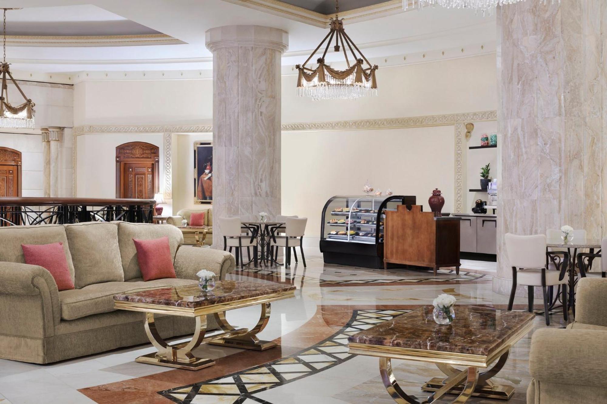 Intercontinental Dar Al Iman Madinah By Ihg Hotell Medina Exteriör bild The image shows a spacious and elegantly designed hotel lobby or lounge area. It features plush sofas with cushions, stylish coffee tables, and decorative elements. The decor includes marble columns and a chandelier hanging from the ceiling, adding t