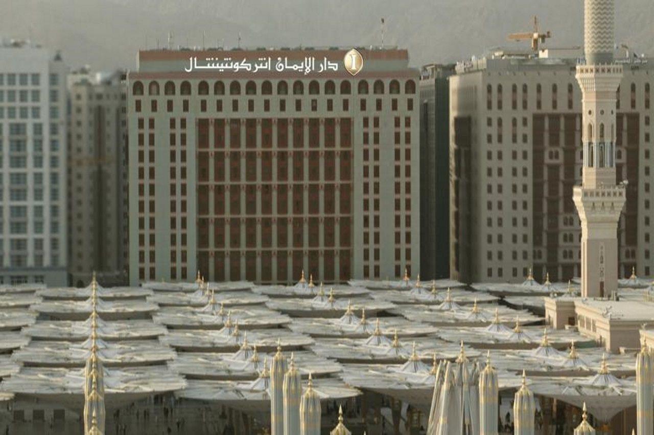 Intercontinental Dar Al Iman Madinah By Ihg Hotell Medina Exteriör bild The photo shows a view of a large building with a modern architectural design, which appears to be a hotel or a commercial establishment. In front of the building, there are several large white canopies that provide shade, likely in a public space or
